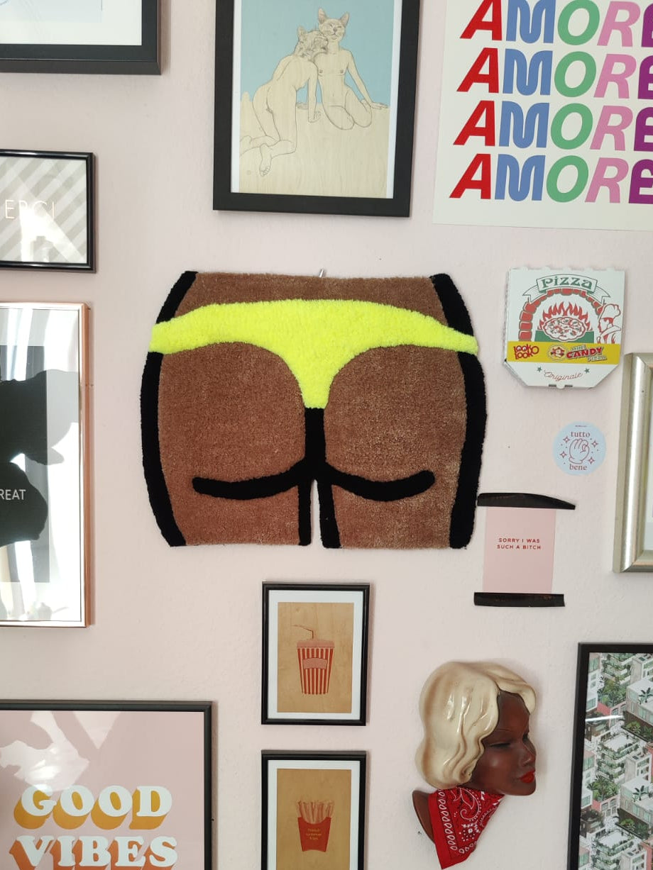 a wall rug / tapestry representing booty in yellow thong, wall decorations around